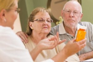 Doctor explaining medication prescription to senior couple