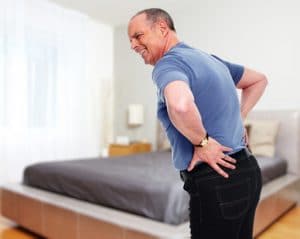 Senior man with back pain at home