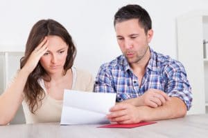 Worried man and woman reading letter at home