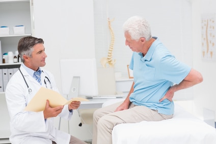 Male patient suffering from back pain speaks with doctor