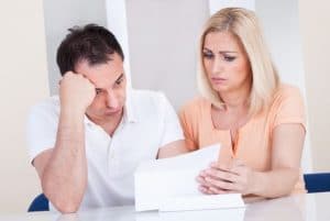 A couple reviewing paperwork looking stressed