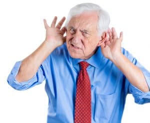 Man with his hands behind his ears trying to hear what is being said